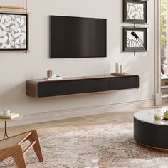 a modern living room with white walls and wood furniture, including a large flat screen tv mounted on the wall