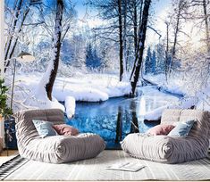 two chairs sitting on top of a rug in front of a wall with snow covered trees