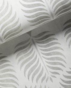 a close up view of a wallpaper with grey and white designs on the paper