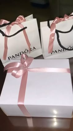 two white boxes with pink ribbons on them