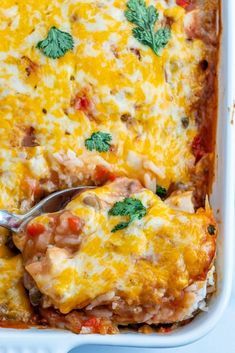 a casserole dish with meat, cheese and vegetables in it on a blue surface