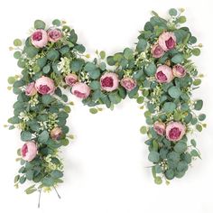 the letter m is made up of flowers and greenery