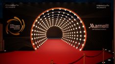 a red carpeted area with an illuminated tunnel at the end that is lit up