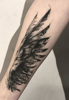 a black and white feather tattoo on the arm