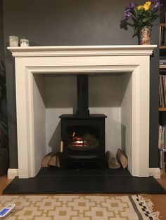 a fire place in the middle of a living room with a rug on the floor