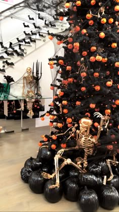 a halloween tree decorated with pumpkins and skeletons