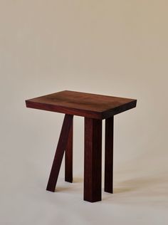 a small wooden table sitting on top of a white floor