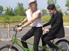 two young men riding bikes in the street