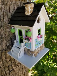 a bird house hanging from the side of a tree