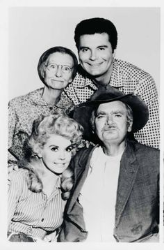 an old black and white photo of three people posing for the camera with one man wearing a cowboy hat