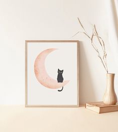 a black cat sitting on top of a pink moon