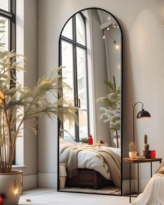 a bedroom with a large mirror on the wall next to a bed and potted plant