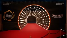 a red carpeted area with an illuminated tunnel at the end that is lit up