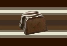 a piece of chocolate cake sitting on top of a table next to a striped wall