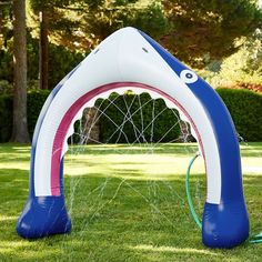 an inflatable soccer goal set up on the grass with a hose attached to it