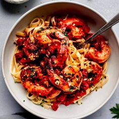 a white bowl filled with pasta and shrimp