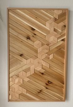 a wooden wall hanging on the side of a white wall