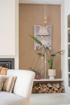 a living room filled with furniture and a fire place next to a wall mounted painting