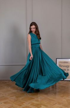 a woman in a teal dress standing on the floor