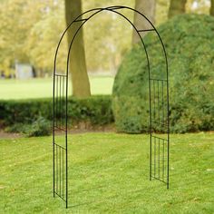 a metal arch in the middle of a grassy area