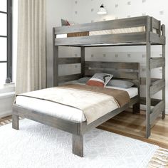 a wooden bunk bed sitting on top of a hard wood floor next to a window