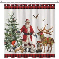 a shower curtain with santa claus and his reindeers next to a christmas tree in the snow