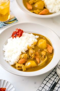 two white bowls filled with food on top of a table