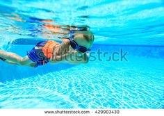 a young boy swimming underwater in the pool