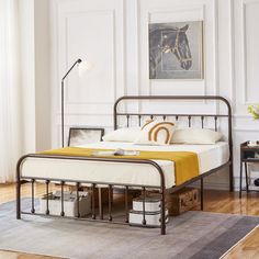 a bedroom with a metal bed frame and yellow blanket on the bottom, along with white walls