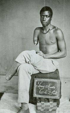 an old photo of a man sitting on top of a suitcase with writing on it