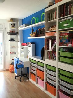 a child's room with lots of shelves and bins on the wall next to a door