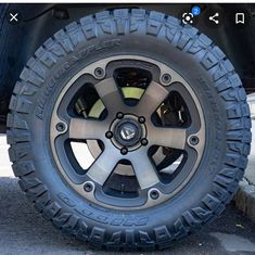 the front wheel and tire of a jeep with black rims on it's tires