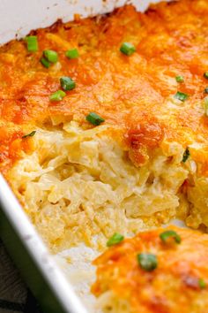 a casserole dish with cheese and green onions in the baking dish, ready to be eaten