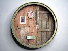 a round mirror with an old door and pictures on it