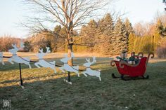 two people riding in a sleigh with reindeers on it