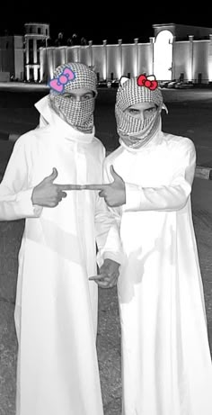 two people in white costumes with red glasses on their faces