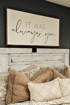 a bed with pillows and a sign above it that says, it was always you