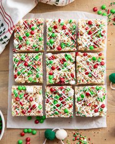 christmas rice krispy kreme treats are arranged on top of parchment paper and sprinkled with candy