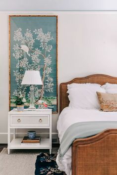 a bedroom with a bed, nightstand and painting on the wall