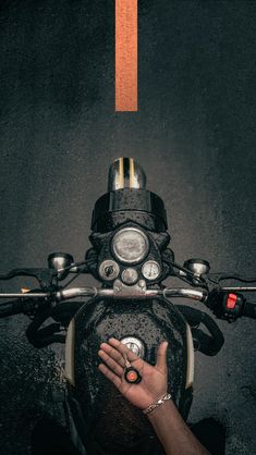 a person is holding their hand on the handlebars of a motorbike