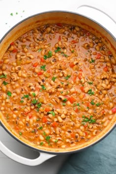 a pot filled with beans and vegetables on top of a table