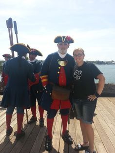 three people in pirate costumes standing on a dock