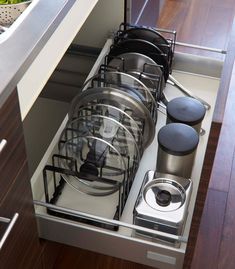 an open drawer with pots and pans in it