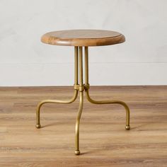 a small wooden table with metal legs and a wood top on a hard wood floor