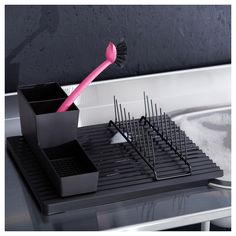 a pink toothbrush sitting in a black holder on top of a counter next to a sink