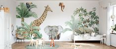 a child's room decorated in white and green with an elephant, giraffe, zebras, and other animals