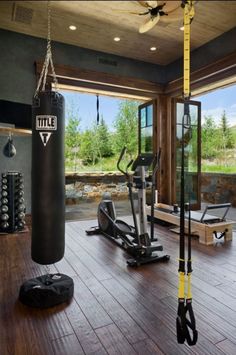 there is a gym with many exercise equipment in the room, including a punching bag