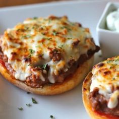 two mini pizzas with cheese and meat on them