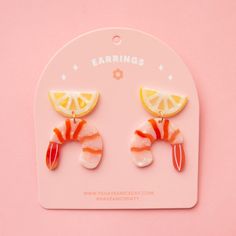 On a pink background is a pair of shrimp cocktail and lemon shaped acetate earrings with a straight back post. Polymer Clay Grape Earrings, Aquatic Earrings, Dnd Earrings, Unique Earrings Weird, Weird Earrings Aesthetic, Chilli Earrings, Fun Earrings Unique, Favorite Things Party Gift Ideas, Shrimp Design