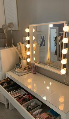 a white vanity with lights on it and drawers